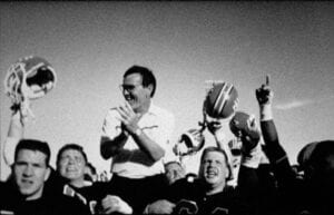 A group of people in the stands cheering on their team.