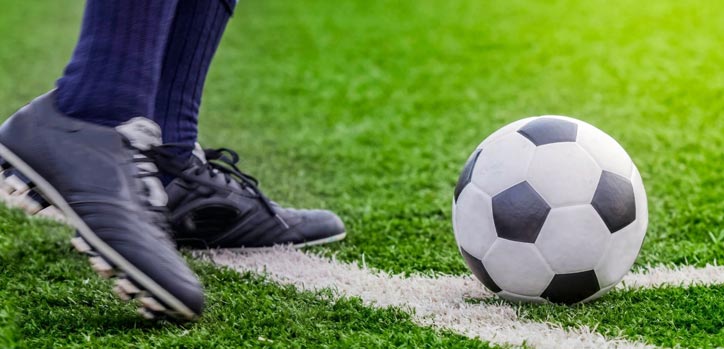 A soccer ball and the feet of a player.