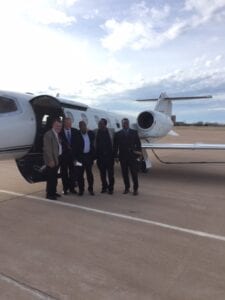 A group of people standing in front of an airplane.